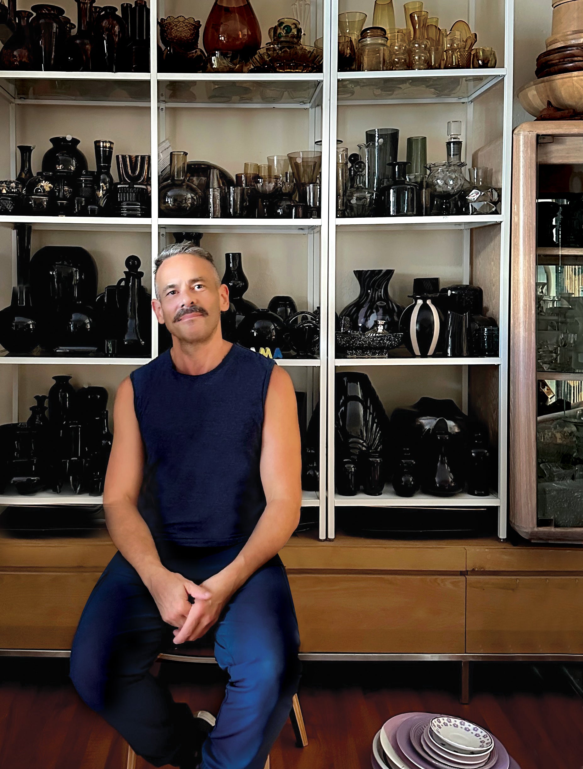 This is an image of the owner of Groupy, Graham Moss, sitting in a chair in the store with vessels in the background.